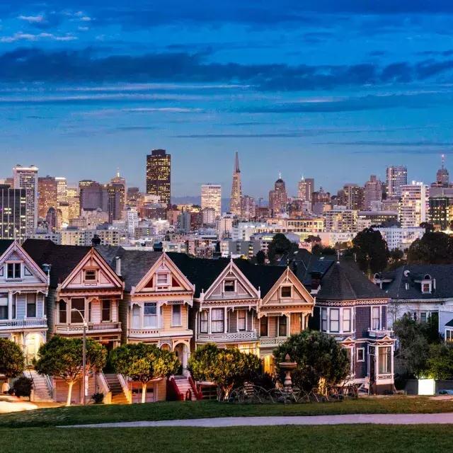 The famous 涂女士 of Alamo Square are pictured before the San Francisco skyline at twilight.